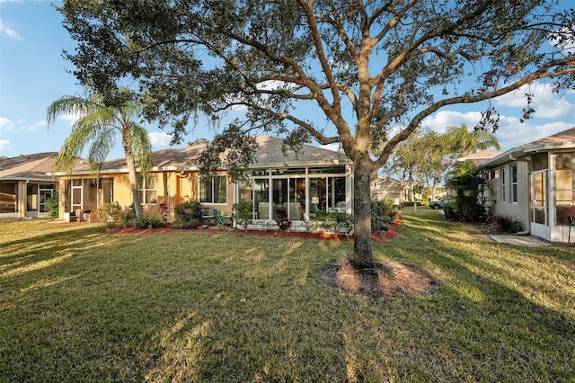 back of house with a yard and a sunroom