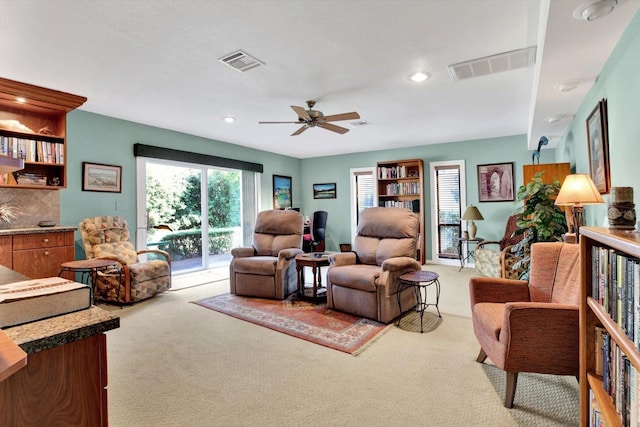 carpeted living room featuring ceiling fan