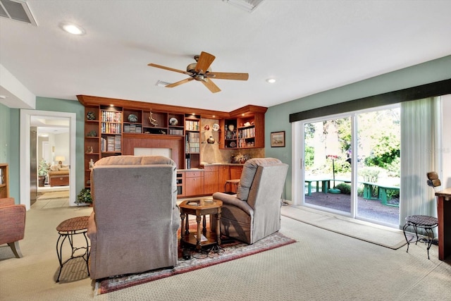 living room with bar area, ceiling fan, and light carpet