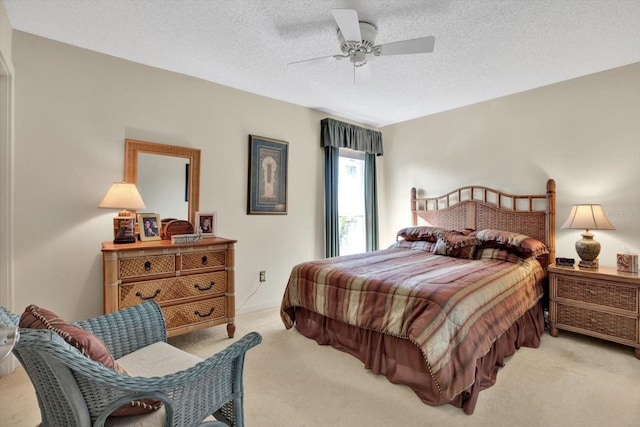 bedroom featuring ceiling fan, light carpet, and a textured ceiling