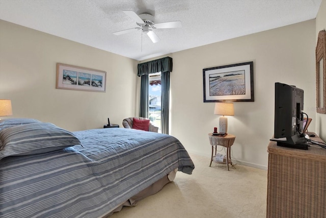 carpeted bedroom featuring ceiling fan and a textured ceiling