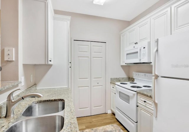 kitchen featuring white cabinetry, sink, light stone counters, light hardwood / wood-style flooring, and white appliances