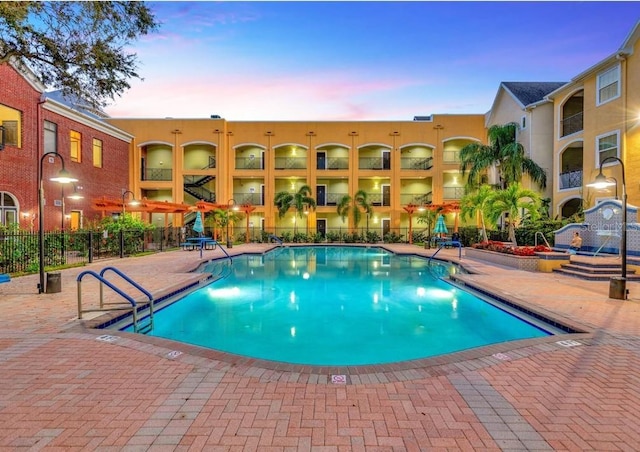 pool at dusk with a patio