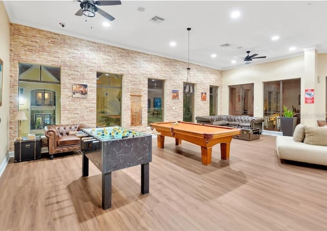 game room featuring brick wall, light wood-type flooring, ceiling fan, and billiards