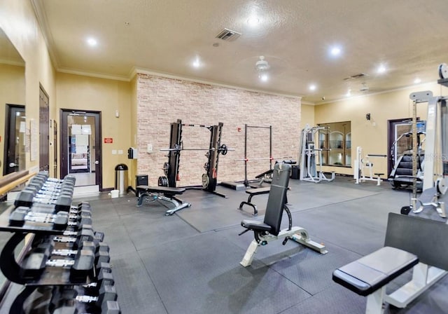 exercise room with ornamental molding and a textured ceiling