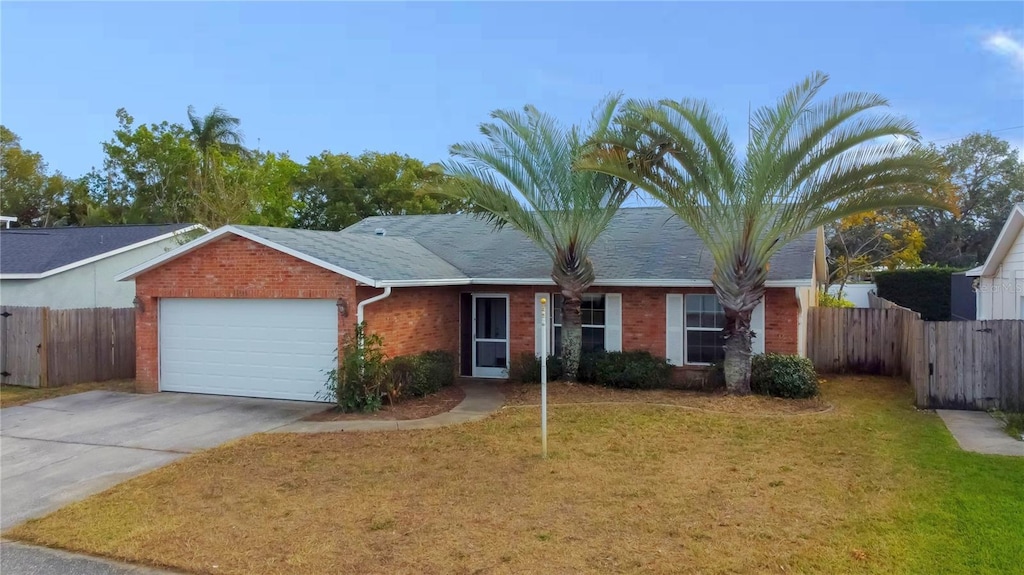 ranch-style house with a garage and a front lawn