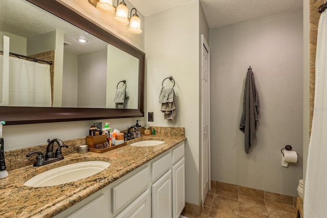 bathroom with toilet, a textured ceiling, and vanity