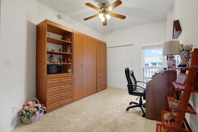 carpeted home office with ceiling fan