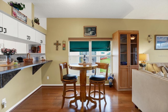 dining room with a textured ceiling and dark hardwood / wood-style floors