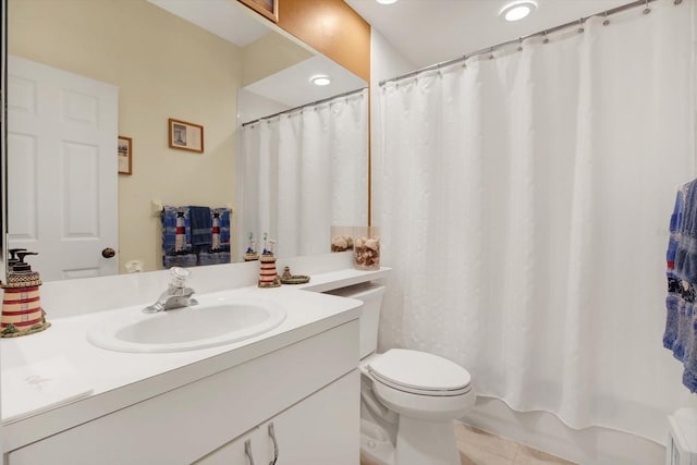 bathroom with toilet, vanity, and tile patterned flooring