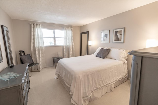 bedroom with light colored carpet and a textured ceiling