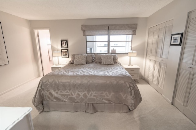 bedroom with a textured ceiling and light carpet