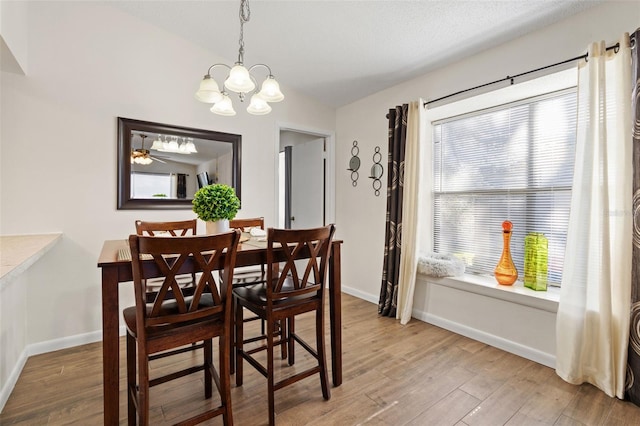 dining space featuring a wealth of natural light, hardwood / wood-style floors, lofted ceiling, and ceiling fan with notable chandelier