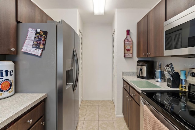 kitchen with light tile patterned flooring, dark brown cabinetry, and appliances with stainless steel finishes