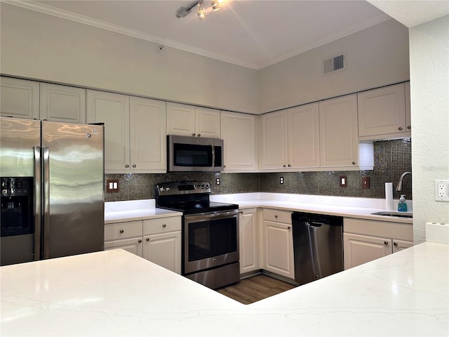 kitchen with decorative backsplash, white cabinets, and appliances with stainless steel finishes