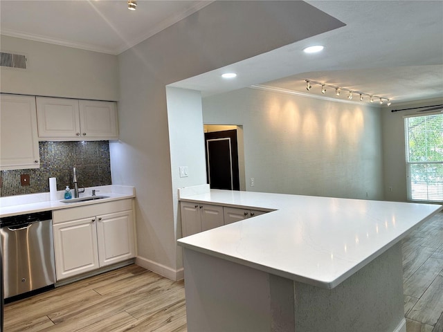 kitchen featuring stainless steel dishwasher, white cabinets, kitchen peninsula, and sink