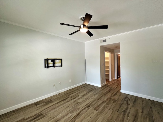 empty room with ceiling fan, dark hardwood / wood-style flooring, and crown molding