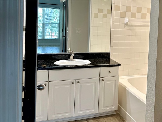 bathroom featuring a tub, wood-type flooring, and vanity