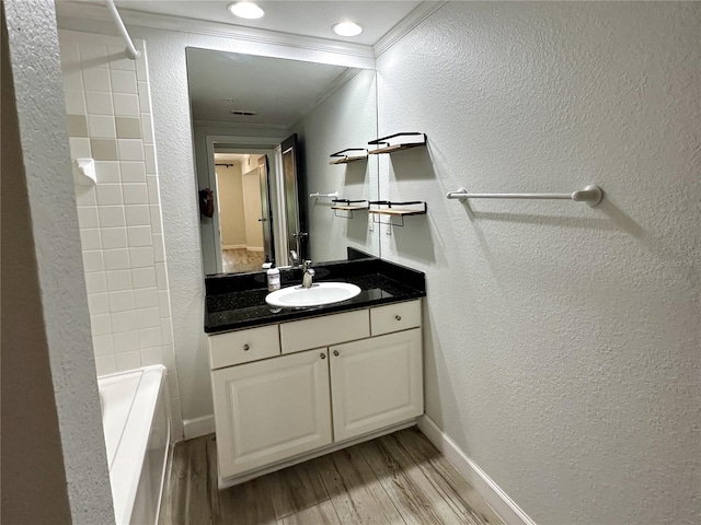 bathroom with hardwood / wood-style flooring, vanity, crown molding, and  shower combination