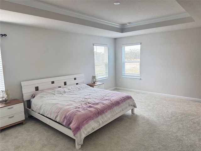 carpeted bedroom featuring a textured ceiling, a raised ceiling, and ornamental molding