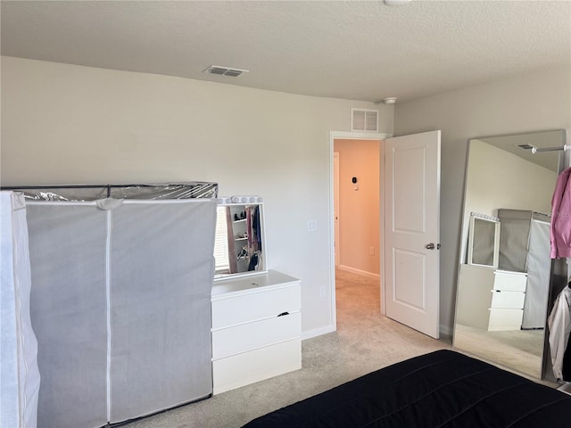 unfurnished bedroom featuring light colored carpet and a textured ceiling