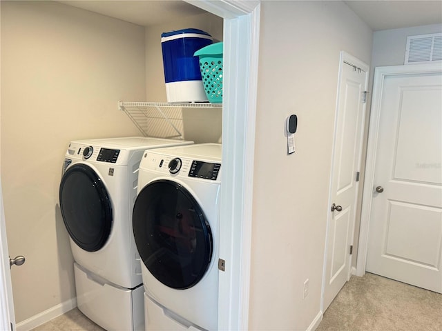 laundry room featuring washing machine and clothes dryer and light colored carpet