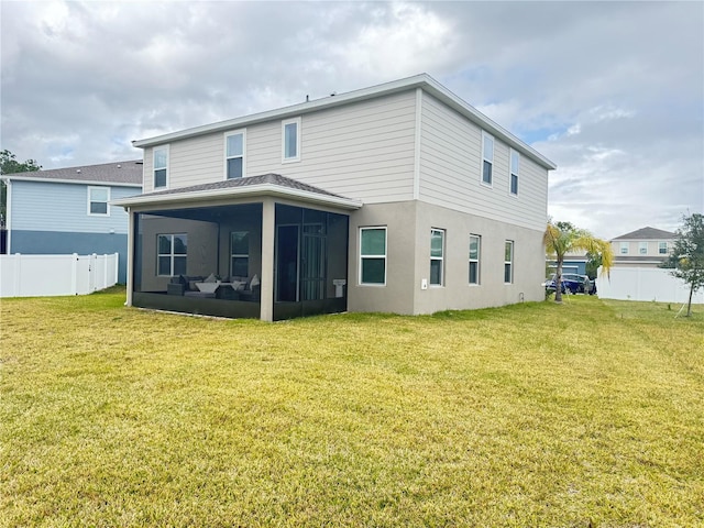 back of house with a yard and a sunroom