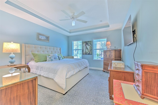 bedroom with ceiling fan, light colored carpet, a tray ceiling, and crown molding