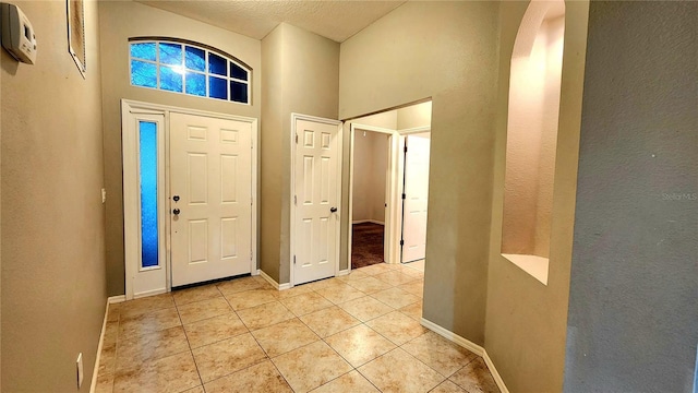 tiled entrance foyer featuring a high ceiling