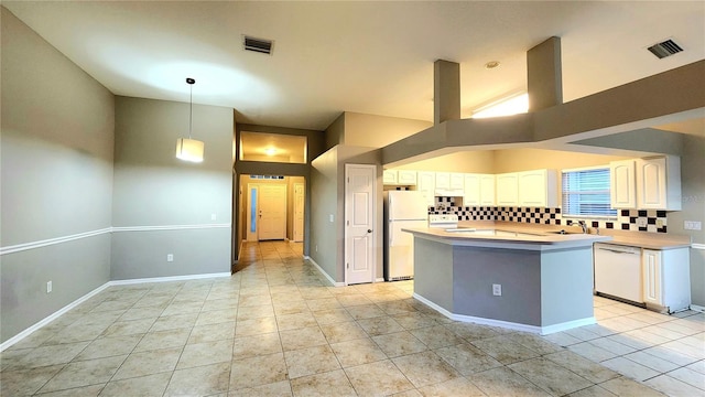 kitchen featuring white appliances, a towering ceiling, tasteful backsplash, decorative light fixtures, and a kitchen island