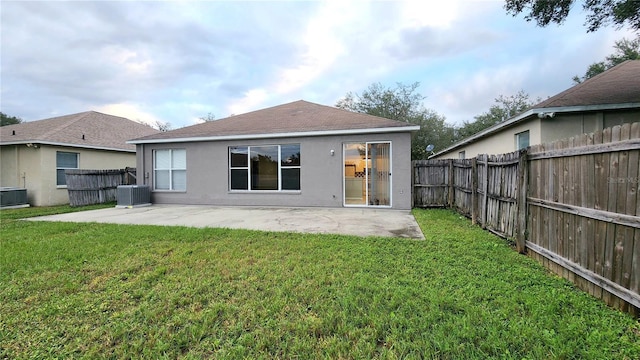 back of house featuring central AC unit, a yard, and a patio