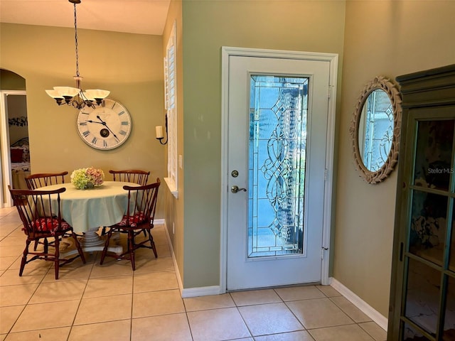 entryway with light tile patterned flooring and a chandelier