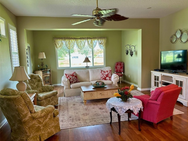 living room featuring a textured ceiling, ceiling fan, and dark hardwood / wood-style floors