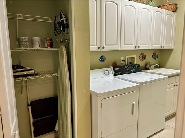 laundry area with cabinets, light tile patterned flooring, washer and clothes dryer, and sink