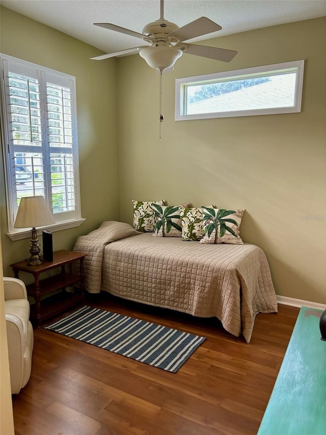 bedroom with wood-type flooring, multiple windows, and ceiling fan