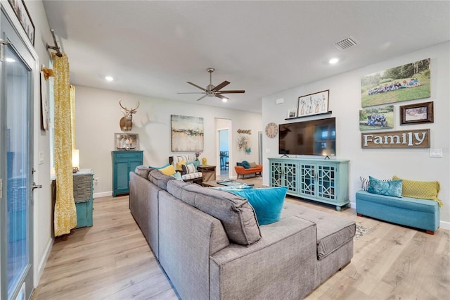 living room with ceiling fan and light hardwood / wood-style flooring