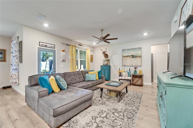 living room with light hardwood / wood-style floors and ceiling fan