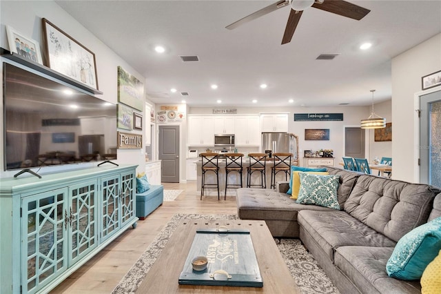 living room with ceiling fan and light hardwood / wood-style floors