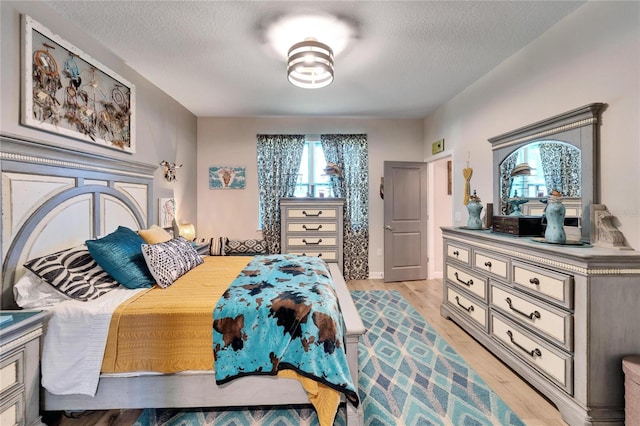 bedroom featuring a textured ceiling and light wood-type flooring