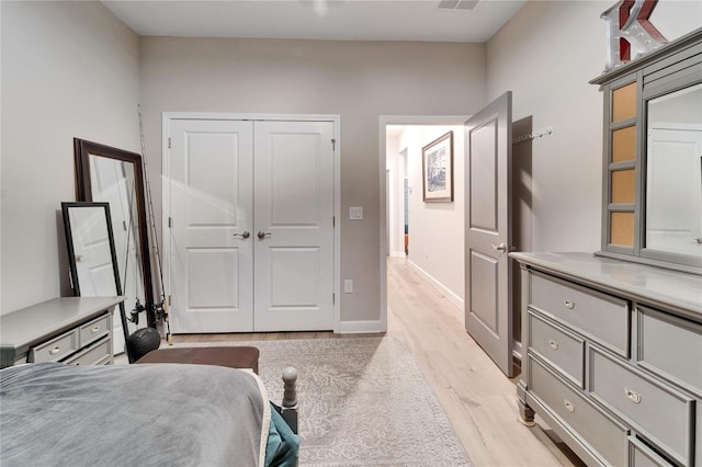 bedroom with a closet and light hardwood / wood-style flooring