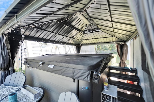 exterior space featuring a hot tub and a gazebo