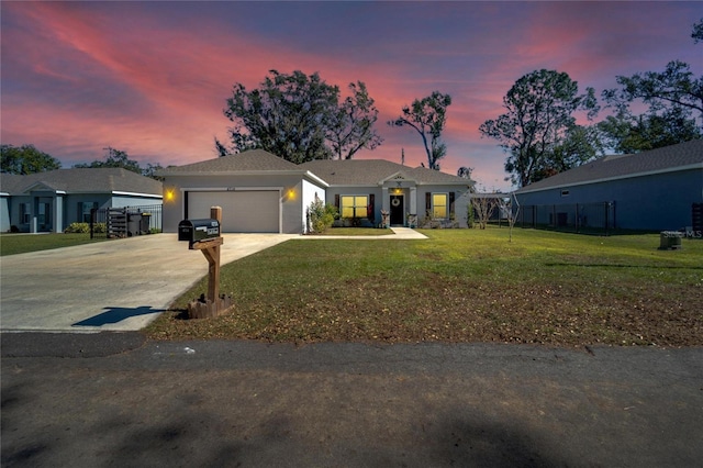 ranch-style home with a garage and a yard