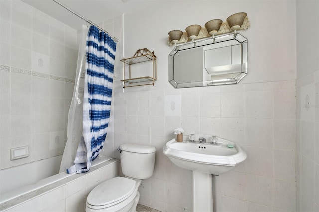 bathroom featuring tile walls, toilet, and shower / tub combo