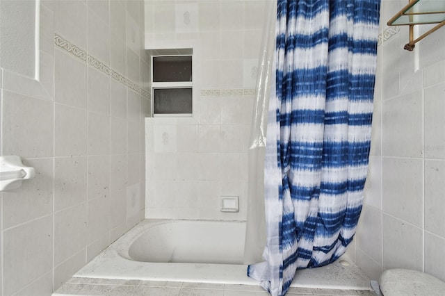 bathroom with tile walls and independent shower and bath