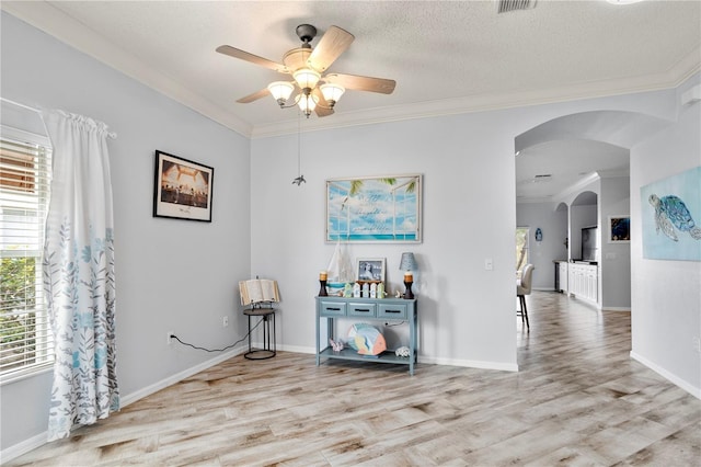 interior space with ceiling fan, crown molding, a textured ceiling, and light hardwood / wood-style floors