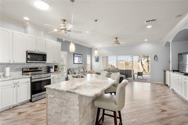 kitchen featuring white cabinets, sink, light stone counters, and stainless steel appliances