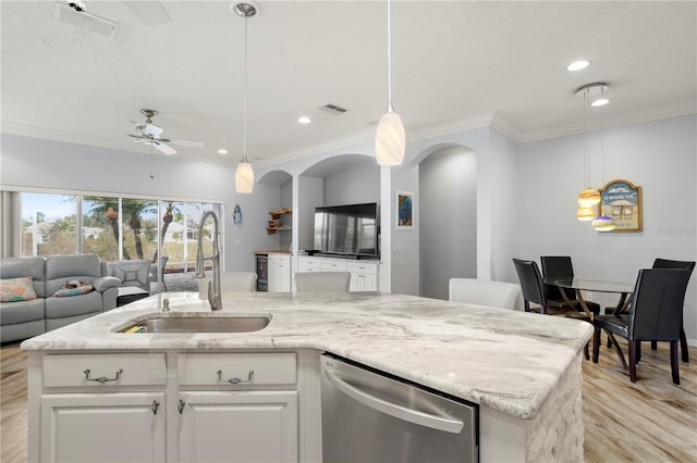 kitchen featuring a kitchen island with sink, dishwasher, sink, and white cabinetry