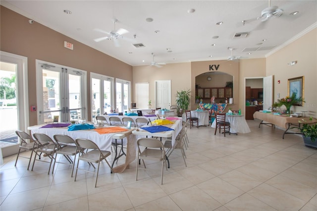 tiled dining area with a high ceiling, a healthy amount of sunlight, and crown molding