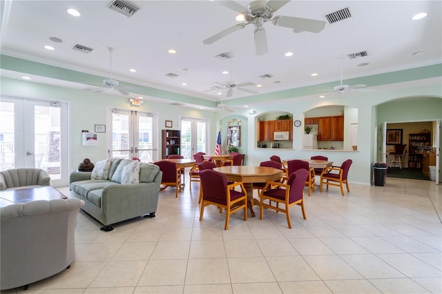 tiled dining room with ornamental molding and french doors