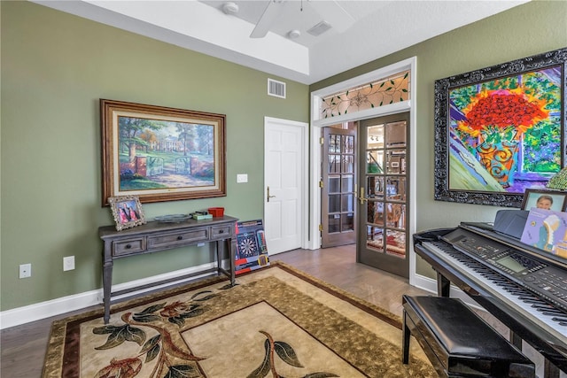 living area with ceiling fan, french doors, and wood-type flooring